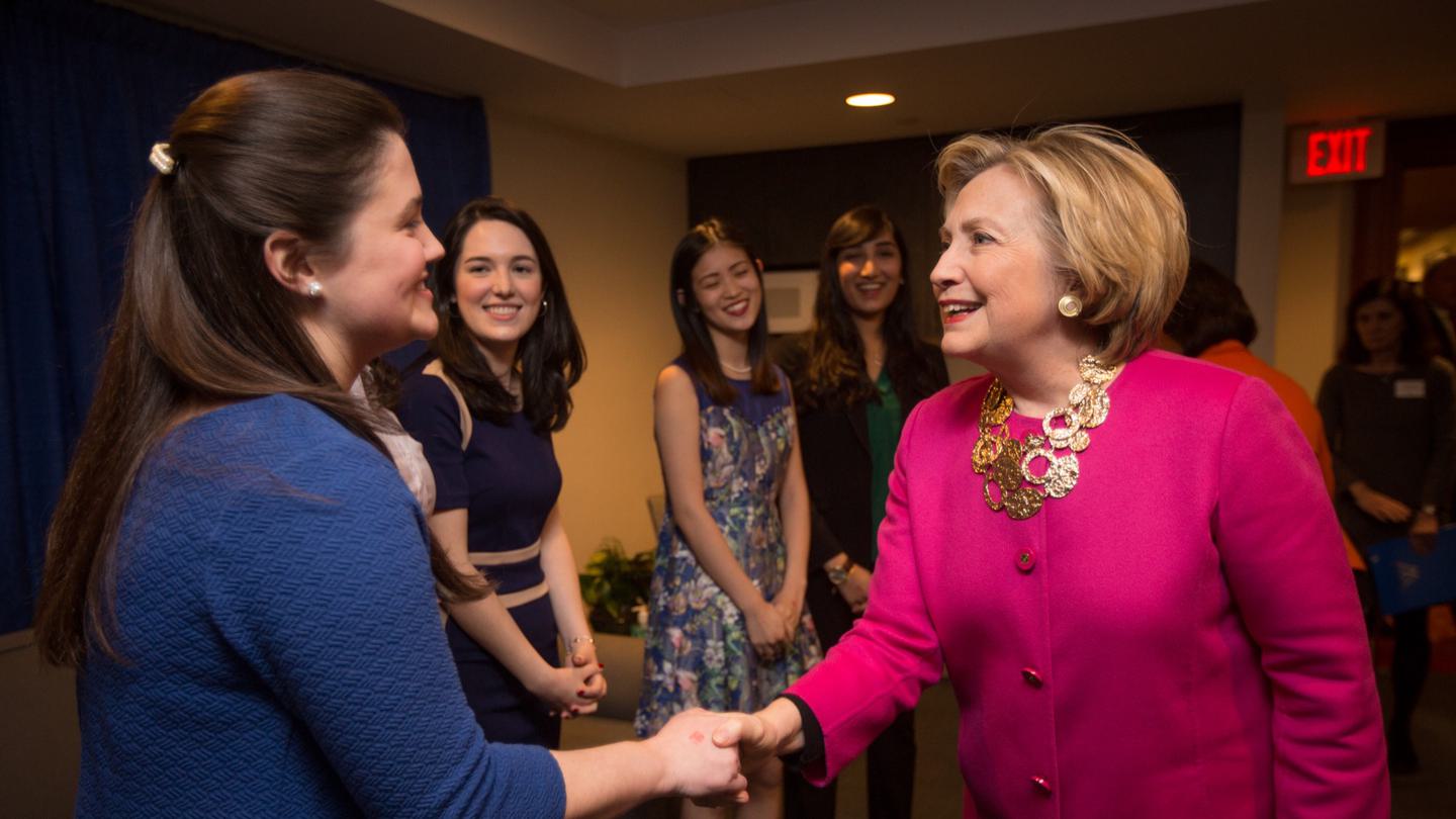 Hillary Clinton shakes hands with a student