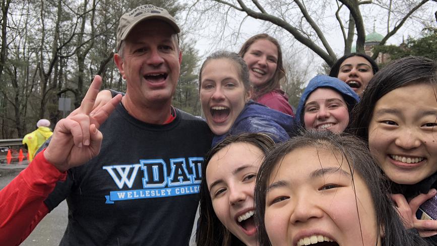 Wellesley College student, Lilly Armstrong, and a group of friends, pose fora  photo cheering on Lilly's dad who is running the Boston Marathon