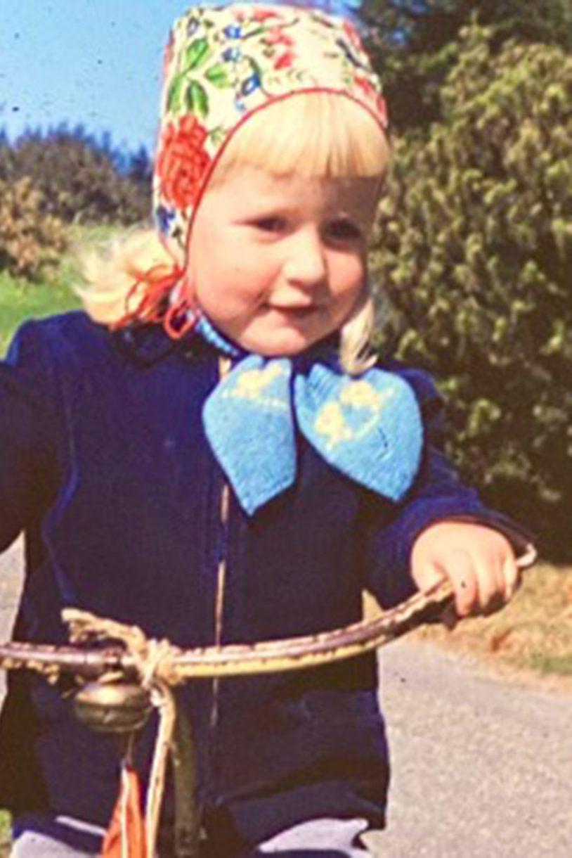 A child with a headscarf rides her bike on Wellesley’s campus.