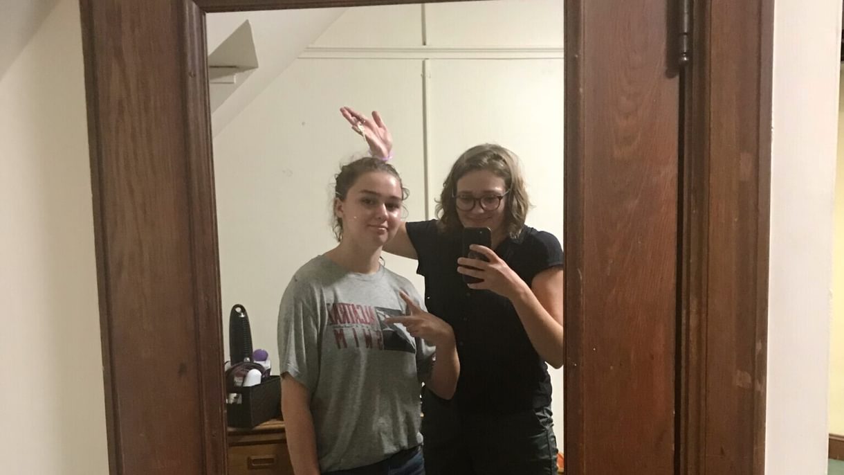 Grace and Bryn as students, reflected in a full length mirror