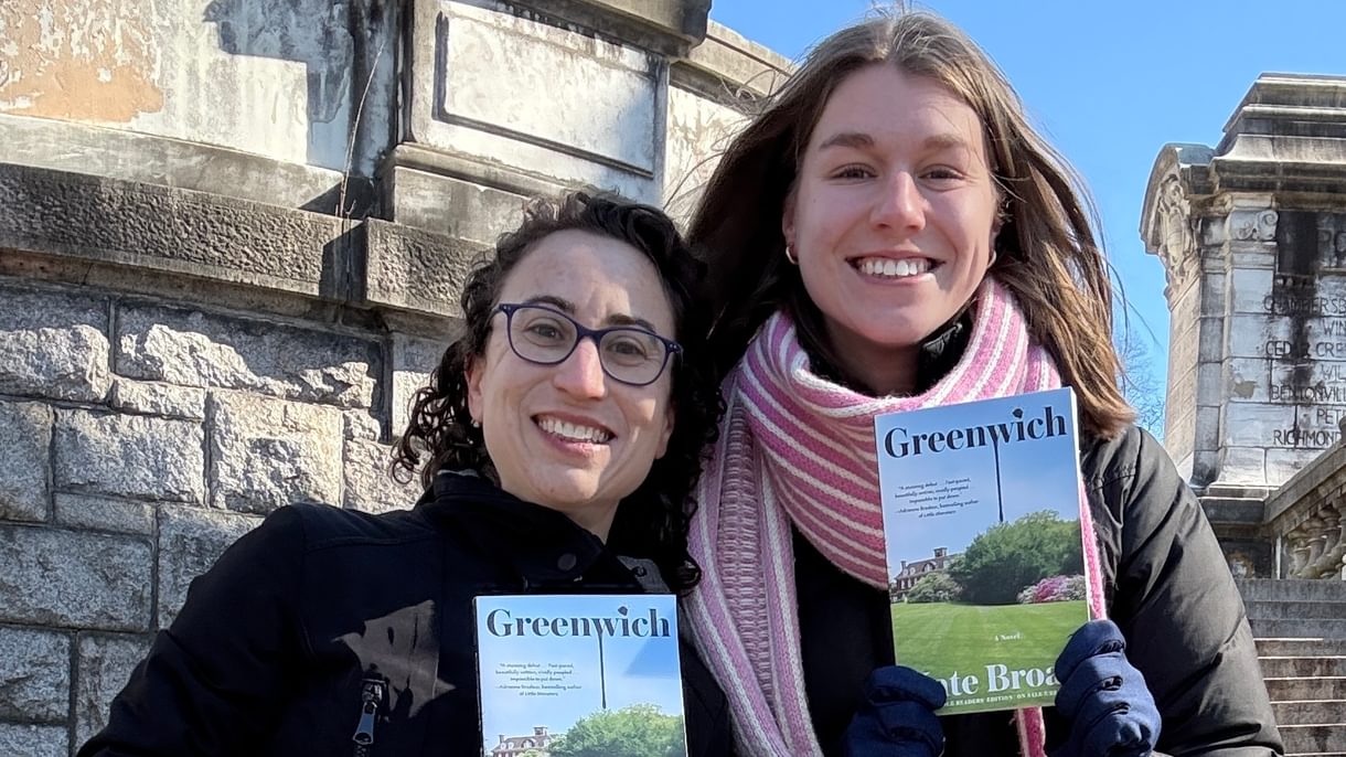 Kate and Claire smiling while holding copies of Kate's book Greenwich