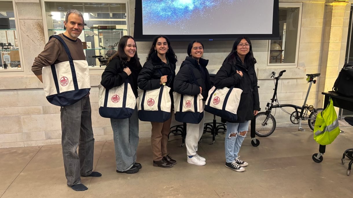 A professor and four students pose with Trader Joe's tote bags