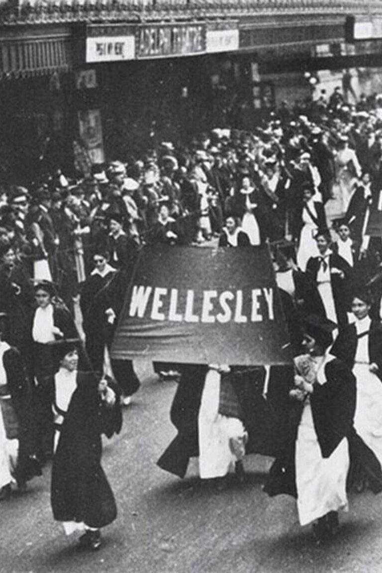 Students carrying banners for Wellesley, Radcliffe, and Swarthmore participate in a march for suffrage in Philadelphia in 1915.