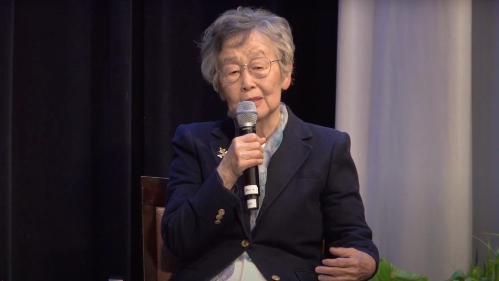Panelist Dr. In Ho Lee seated on stage, holding microphone