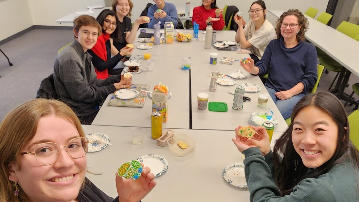 Araceli and her neuroscience peers sit around a table display their decorated brain cookies