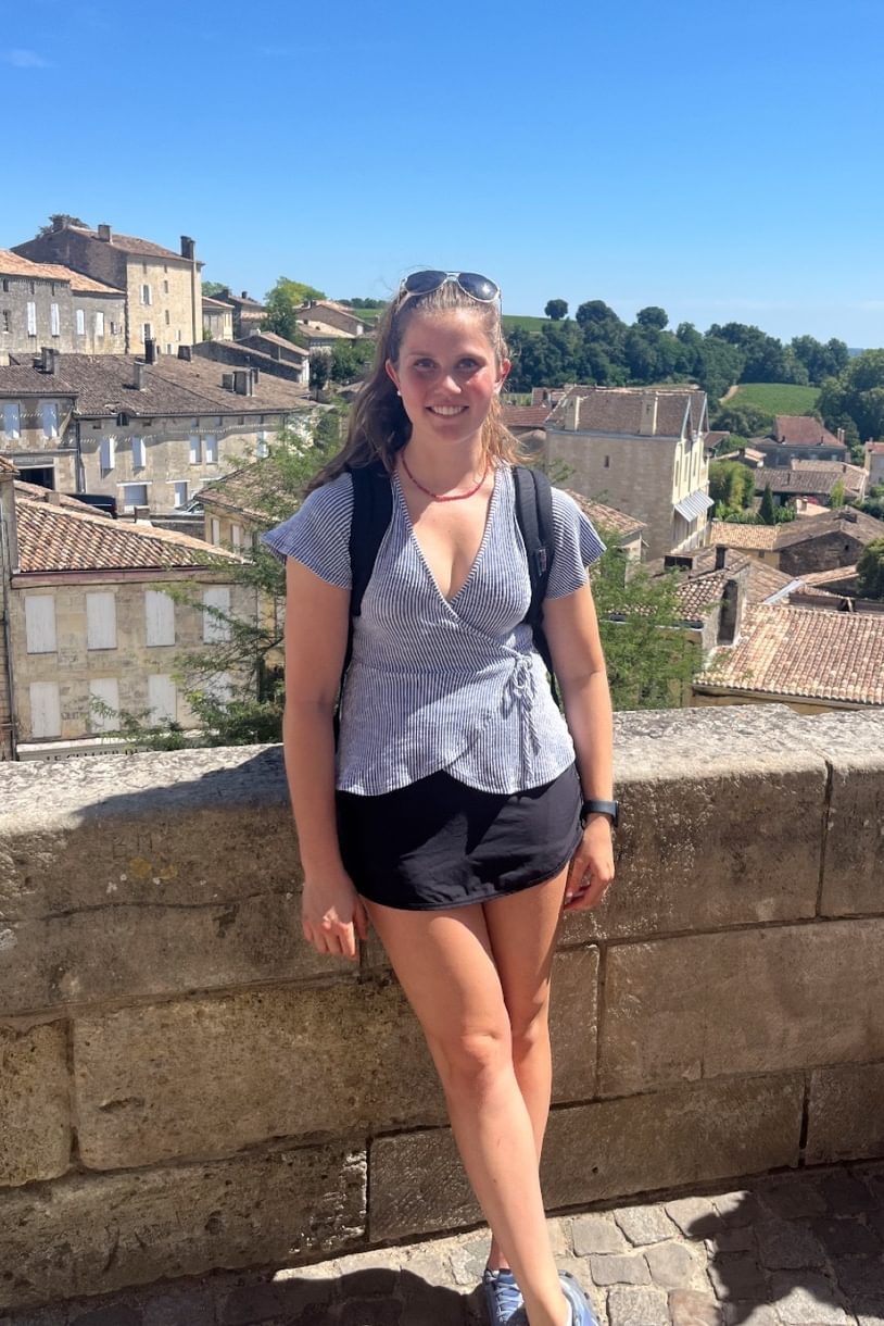 Erin stands against a stone wall