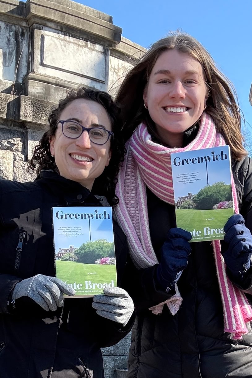 Kate and Claire smiling while holding copies of Kate's book Greenwich