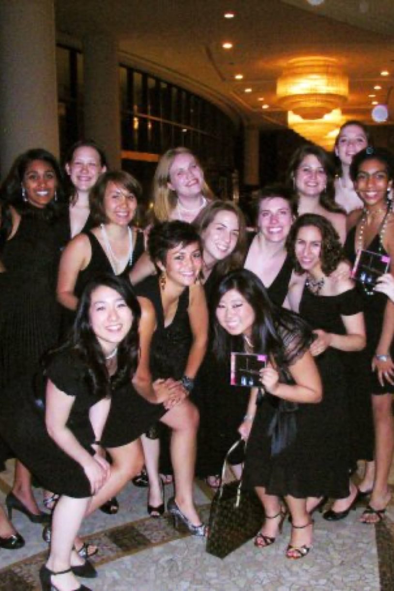 Students in black dresses pose while holding CD cases