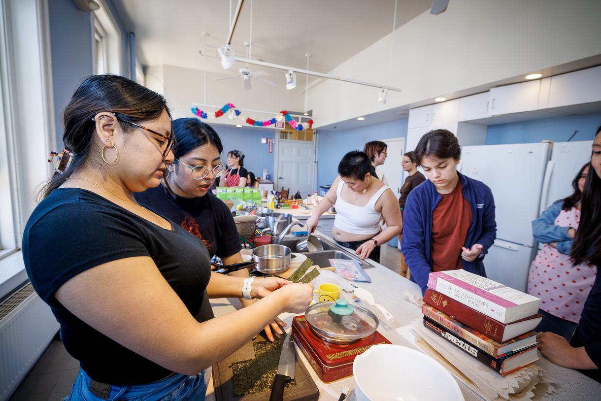 Students rinse rice and cut nori while making musubi