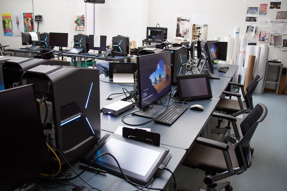An empty Media Arts Lab with multiple desktop PCs set up at tables. The PC in the foreground shows the time of 2:04.