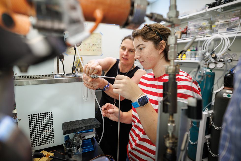 Rachel Stanley helping student adjust equipment