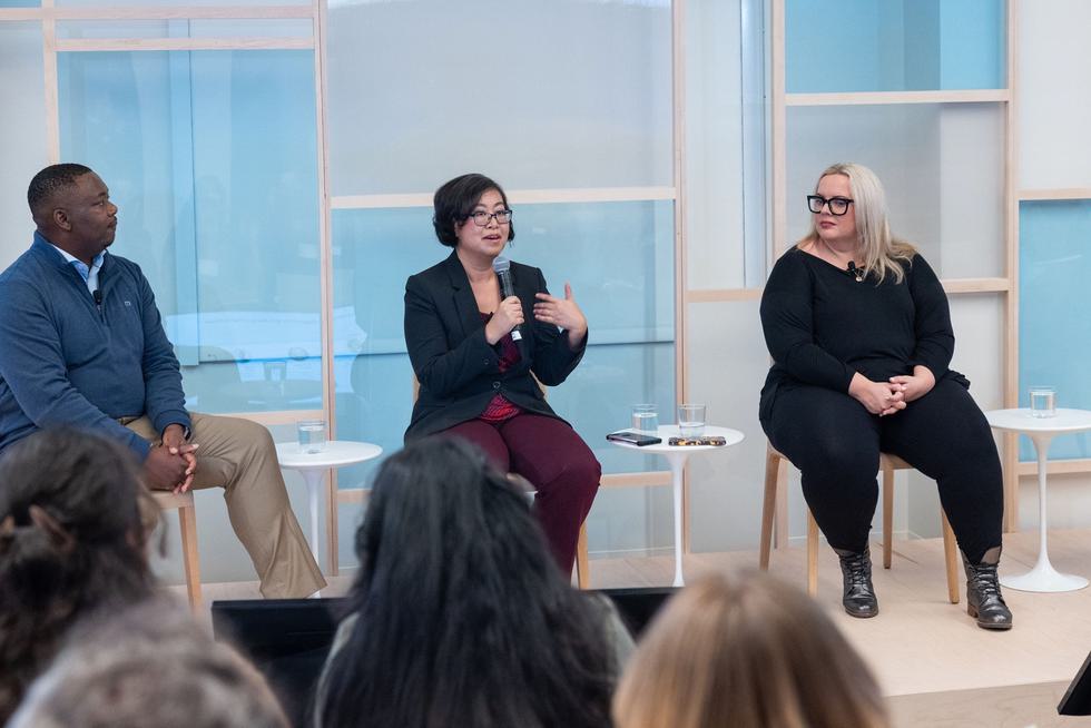 Linda Charmaraman and three other panelists speak at an event. Linda has the microphone and is speaking in this image.
