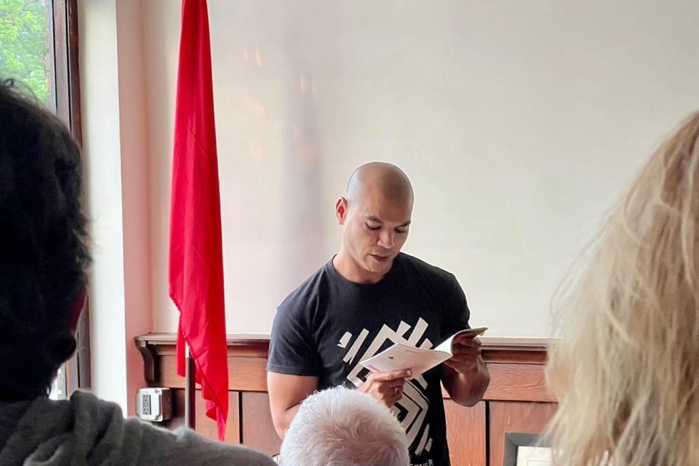 Tavi González reads a book to an audience.