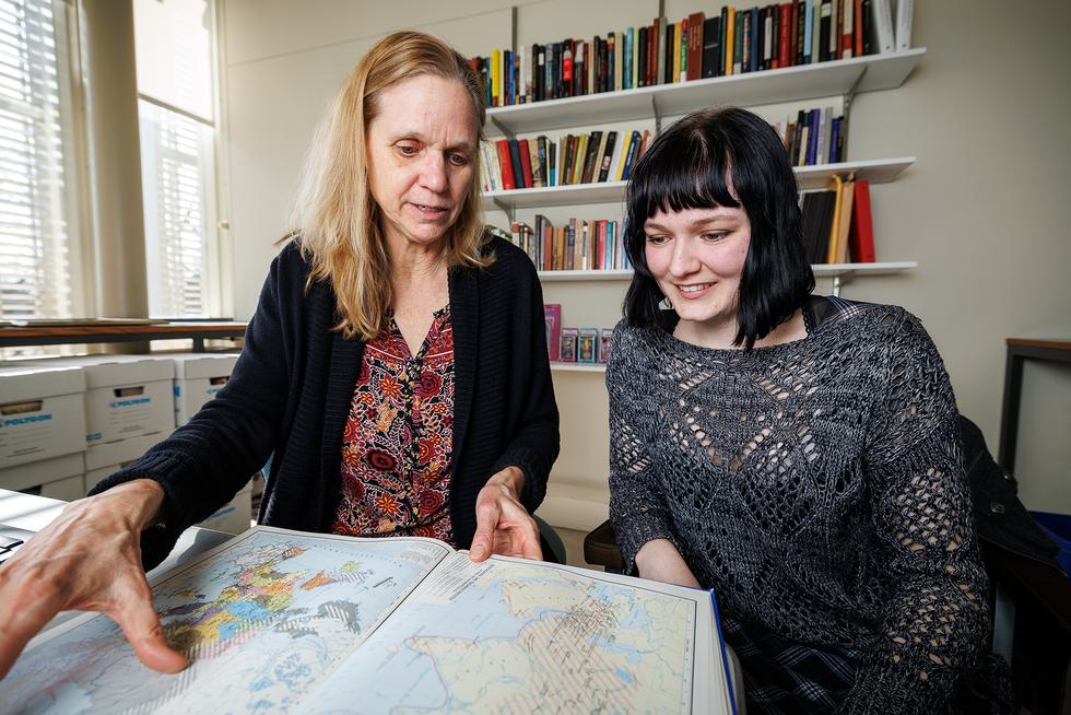 Valerie Ramseyer shows a student a book of maps.