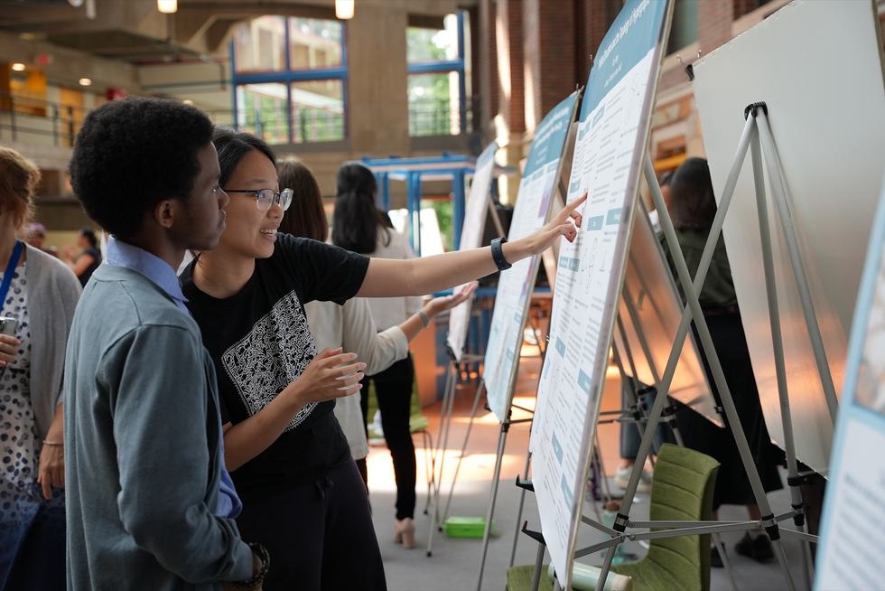 Student explaining their poster during a poster session in the science center.