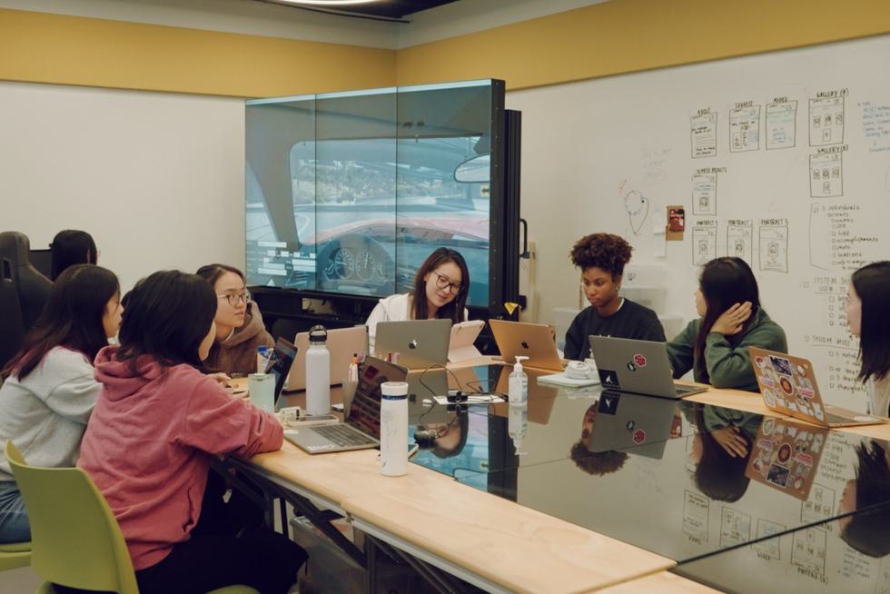 Students sit around the table in the Human-Computer Interaction lab.