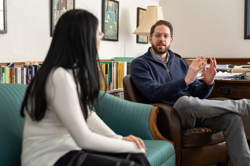 Professor Erich Hatala Matthes speaks with a student in his office.