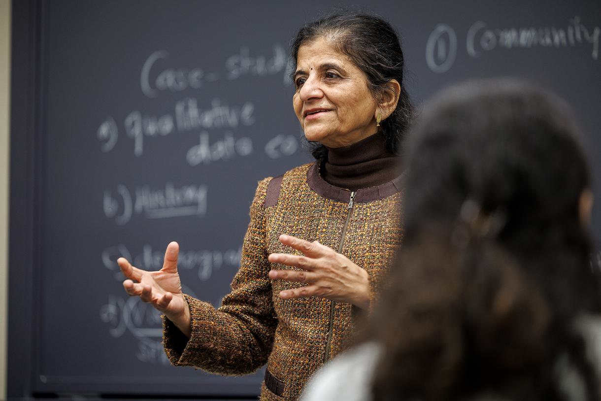 Professor Neelima Shukla-Bhatt to her class in front of a chalkboard.