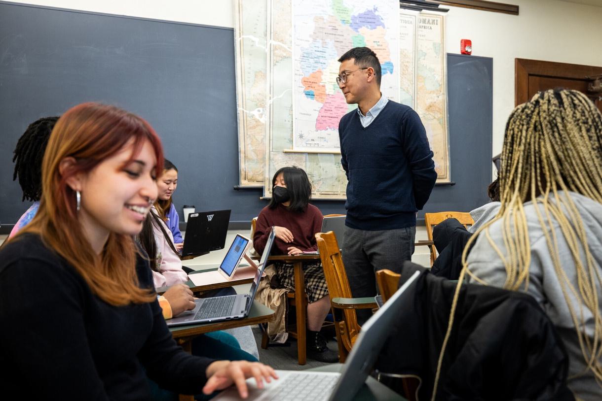 Koichi Hagimoto walks around his classroom as students work on their laptops.