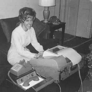 Elizabeth “Betsy” Wood Knapp ’64 seated at a teletype machine