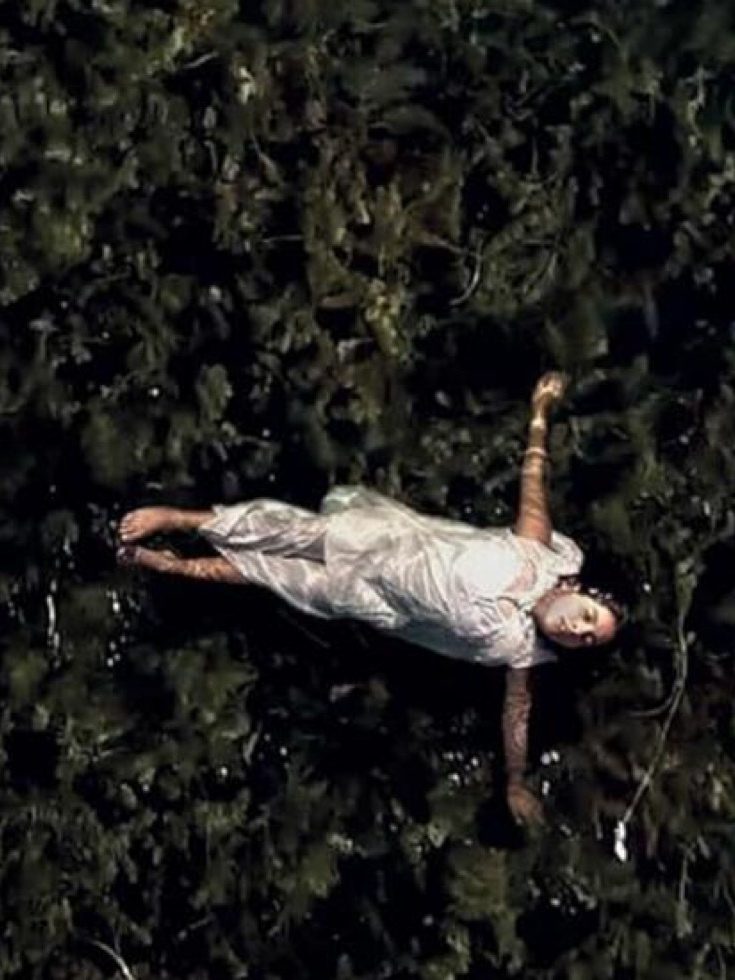 Overhead view of woman floating on her back in water with arms outstretched