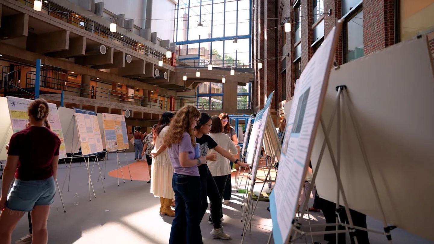 Students look at many posters set up in the Science Center.