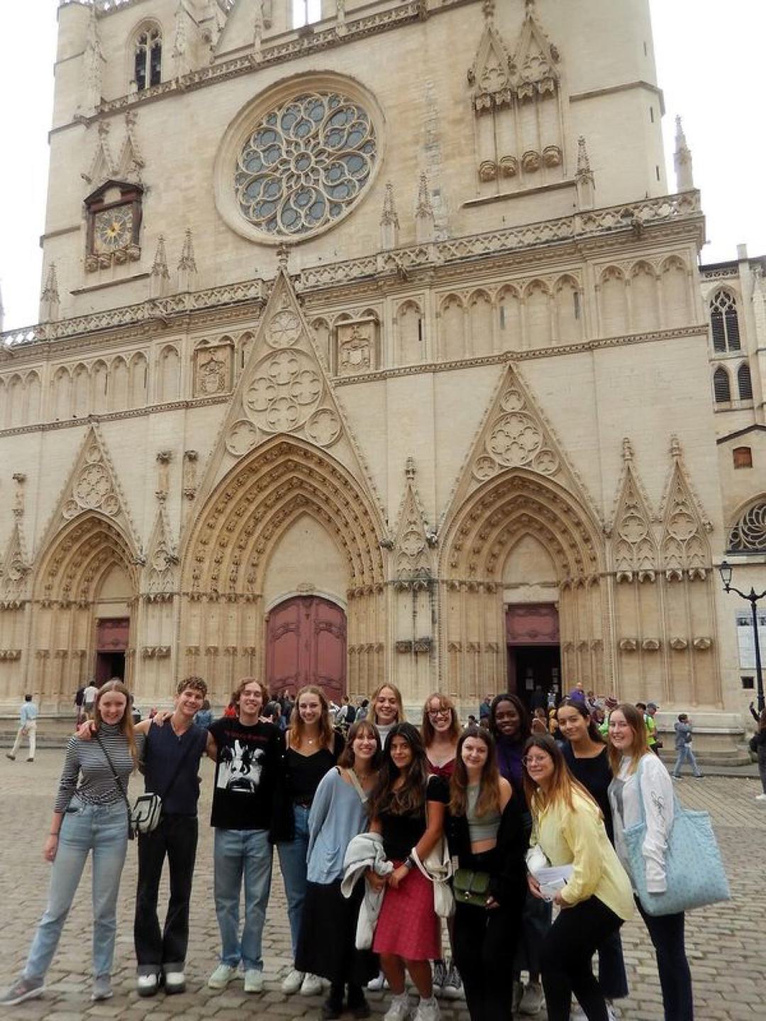 A group of students poses in front of a church.