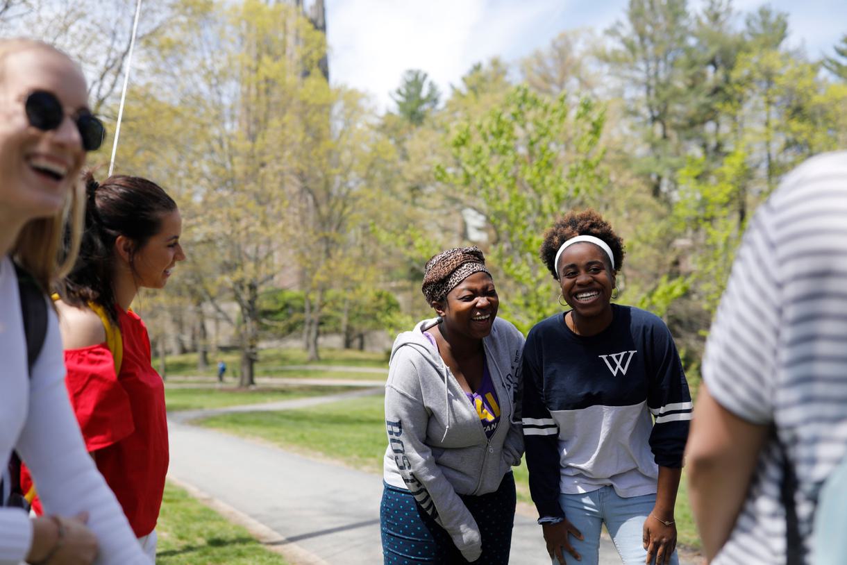Students laughing outside on the path between the Science Complex and Green Hall.