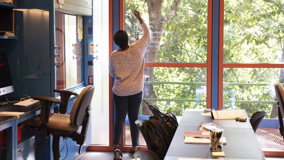 A student writes on a window, using it as a whiteboard