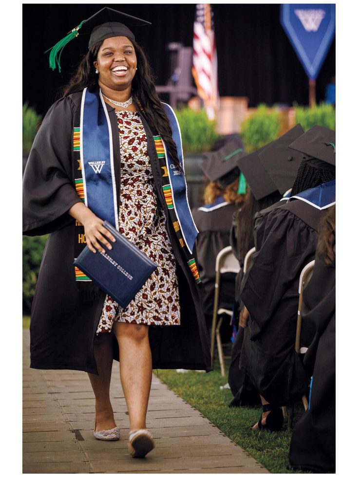 A photo of a smiling student processing during commencement