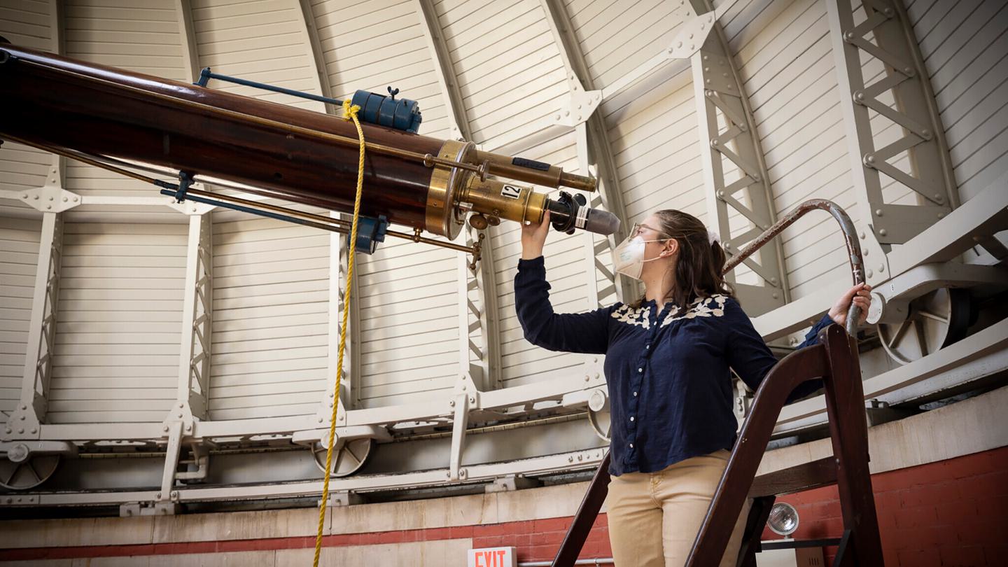 Student looking into the telescope in the observatory