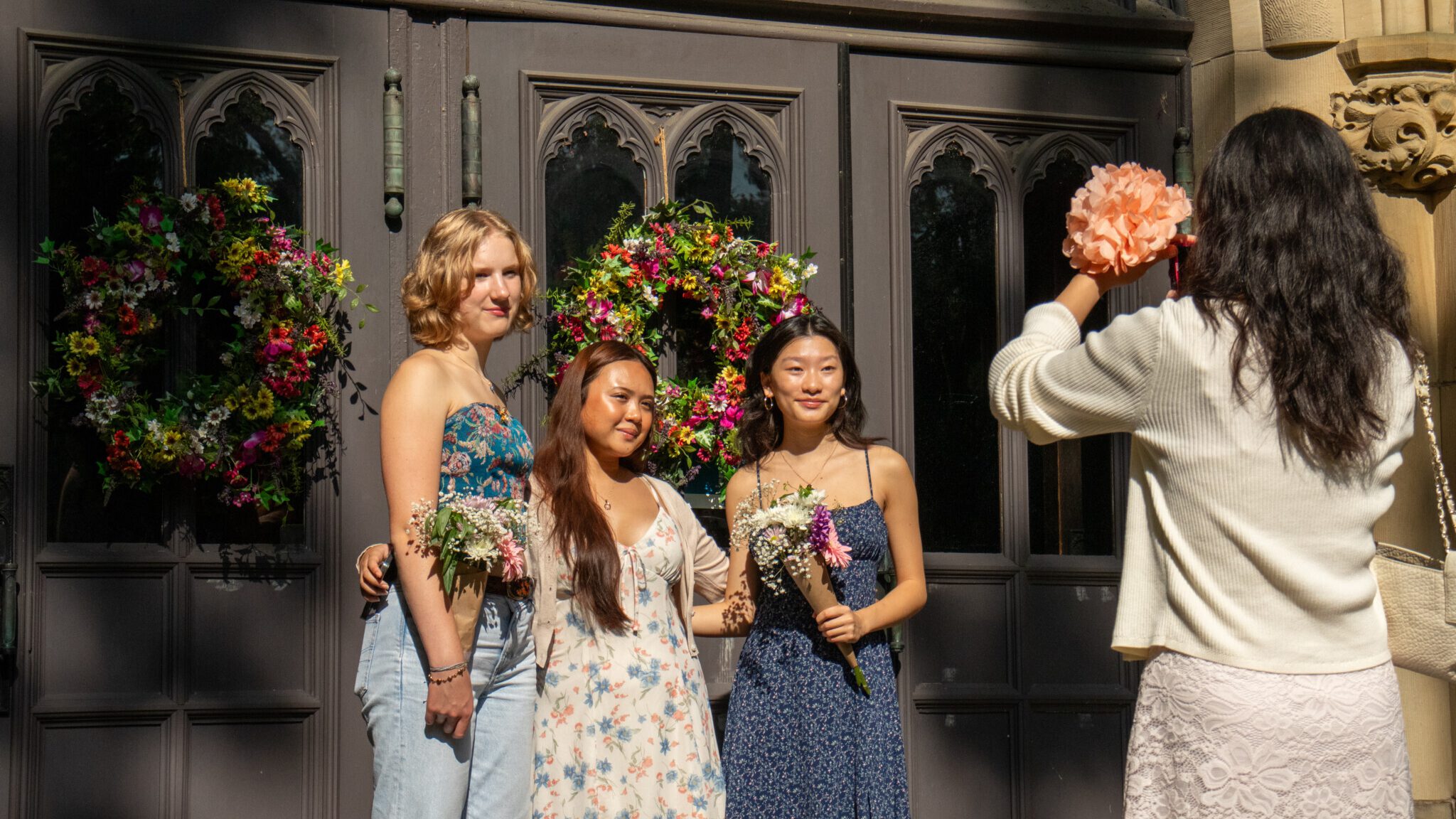 Three students stand in front of the chapel doors for a photo.