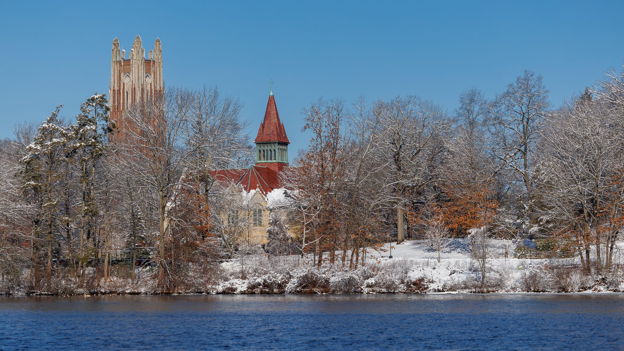 A winter scene showing Lake Waban, the top of Galen Tower and the top of Billings.