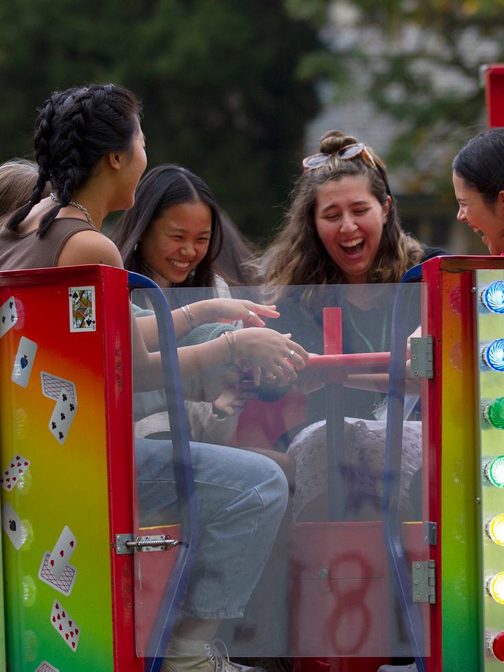 Students on a colorful carnival ride smiling and laughing