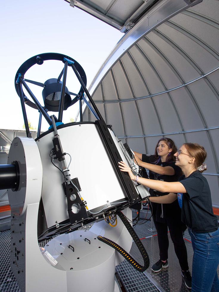 Students adjust the position of a PlaneWave telescope