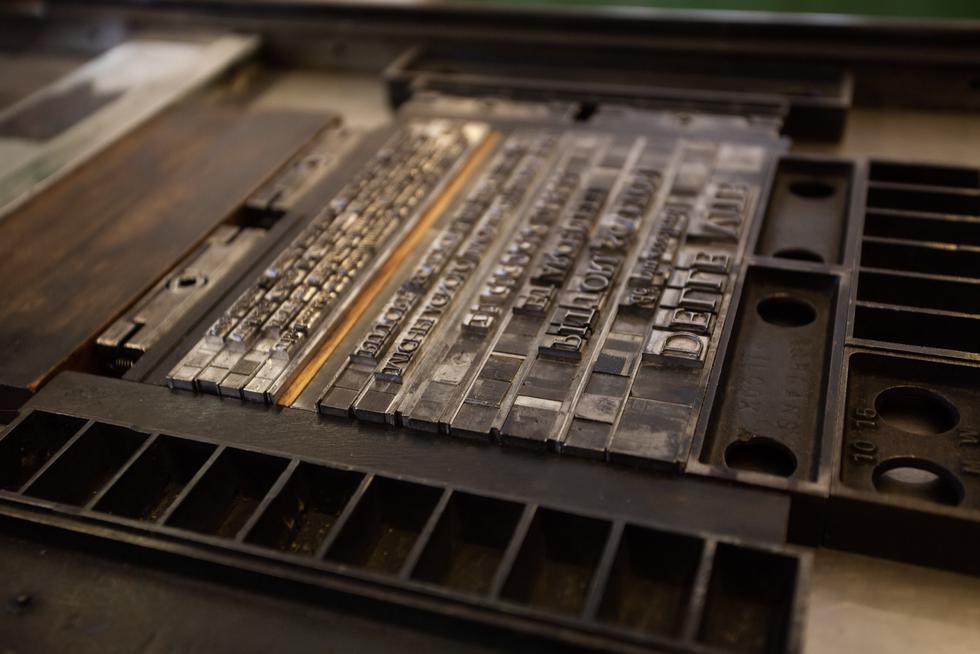 Metal letters laid out on a printing press.
