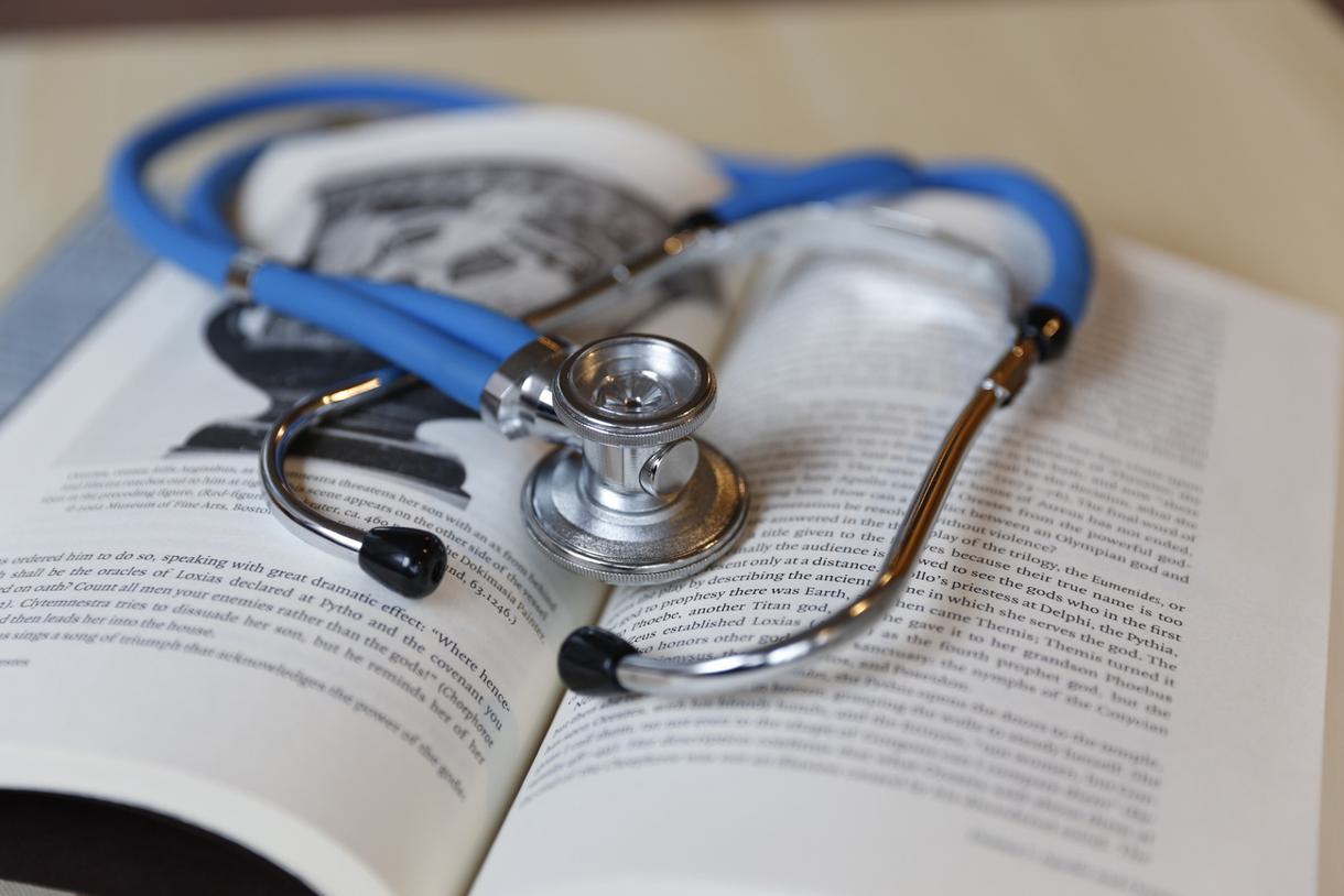Stethoscope laying on an open book.