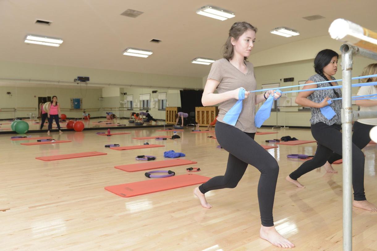 pull on resistance bands during a group pilates class.