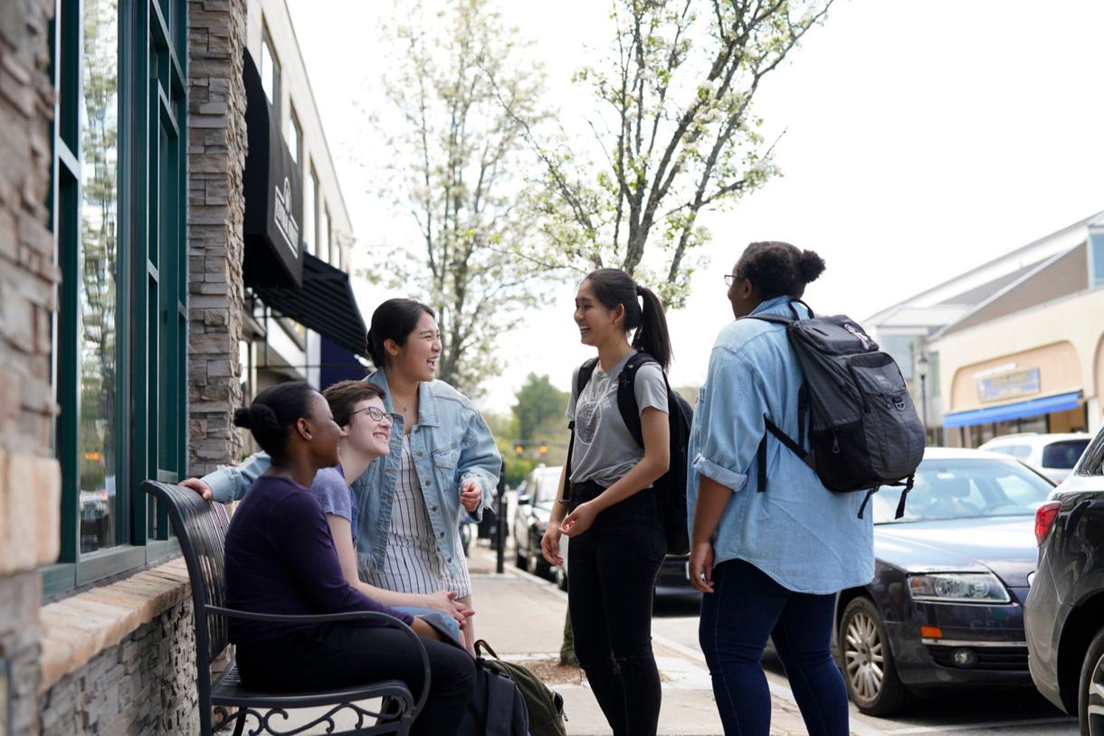 Students chat and laugh while hanging out in downtown Wellesley.