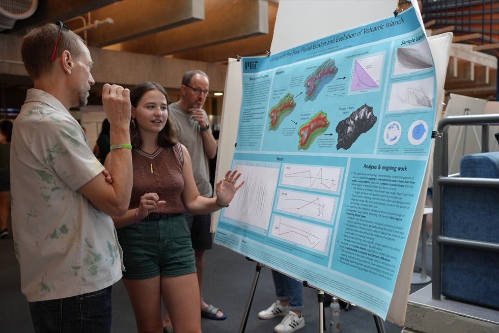 A student explains her poster to a listener during a poster session.