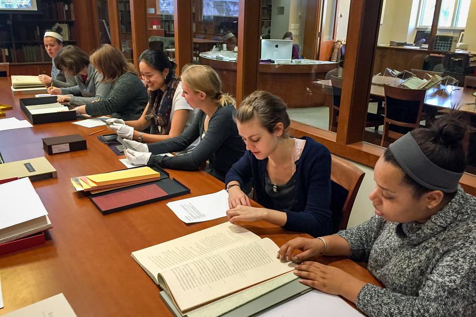 Students sit around a table talking in the special collections section of the library.