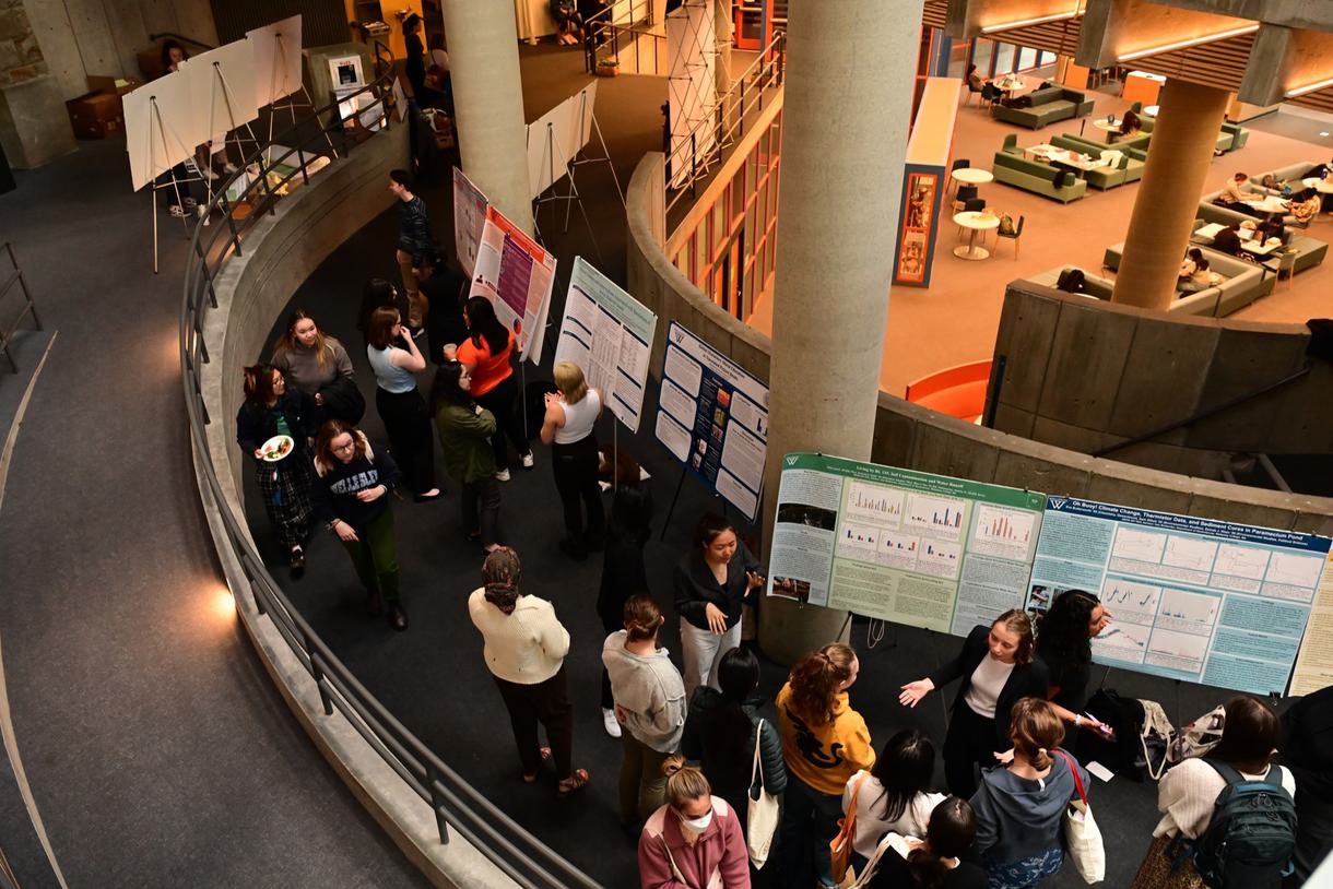 Overhead view looking down into a crowd at a poster session.