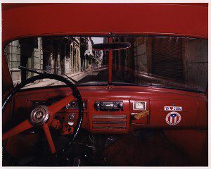 Red interior truck dashboard with windshield view of Haban Vieja Street in Cuba
