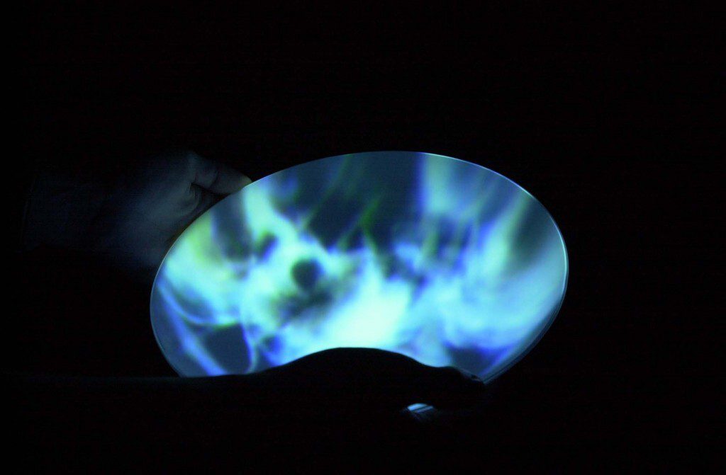 Ocean blue orb-like shape projected as an installation in a dark room