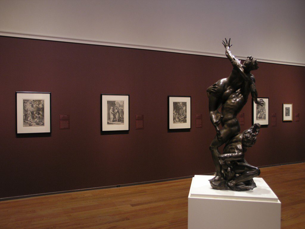 Large bronze statue of nude figures climbing on each other and reaching upwards