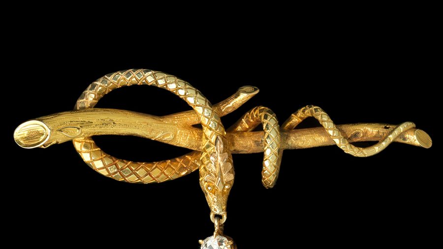 Pin of a gold serpent wrapped around a gold branch