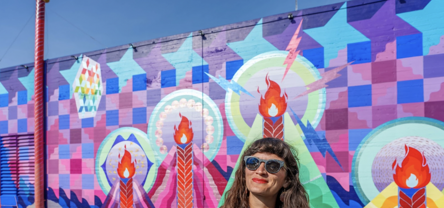 Portrait of Maria Molteni standing in front of the Seven Sisters mural