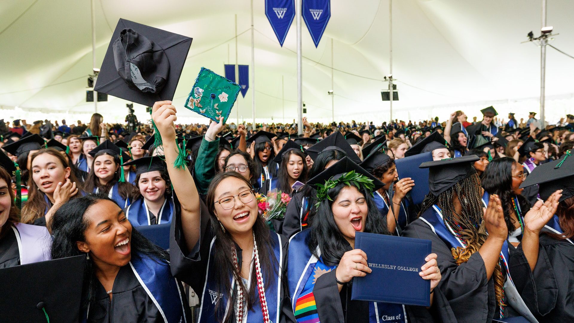 Members of the class of 2025 wave their caps in the air