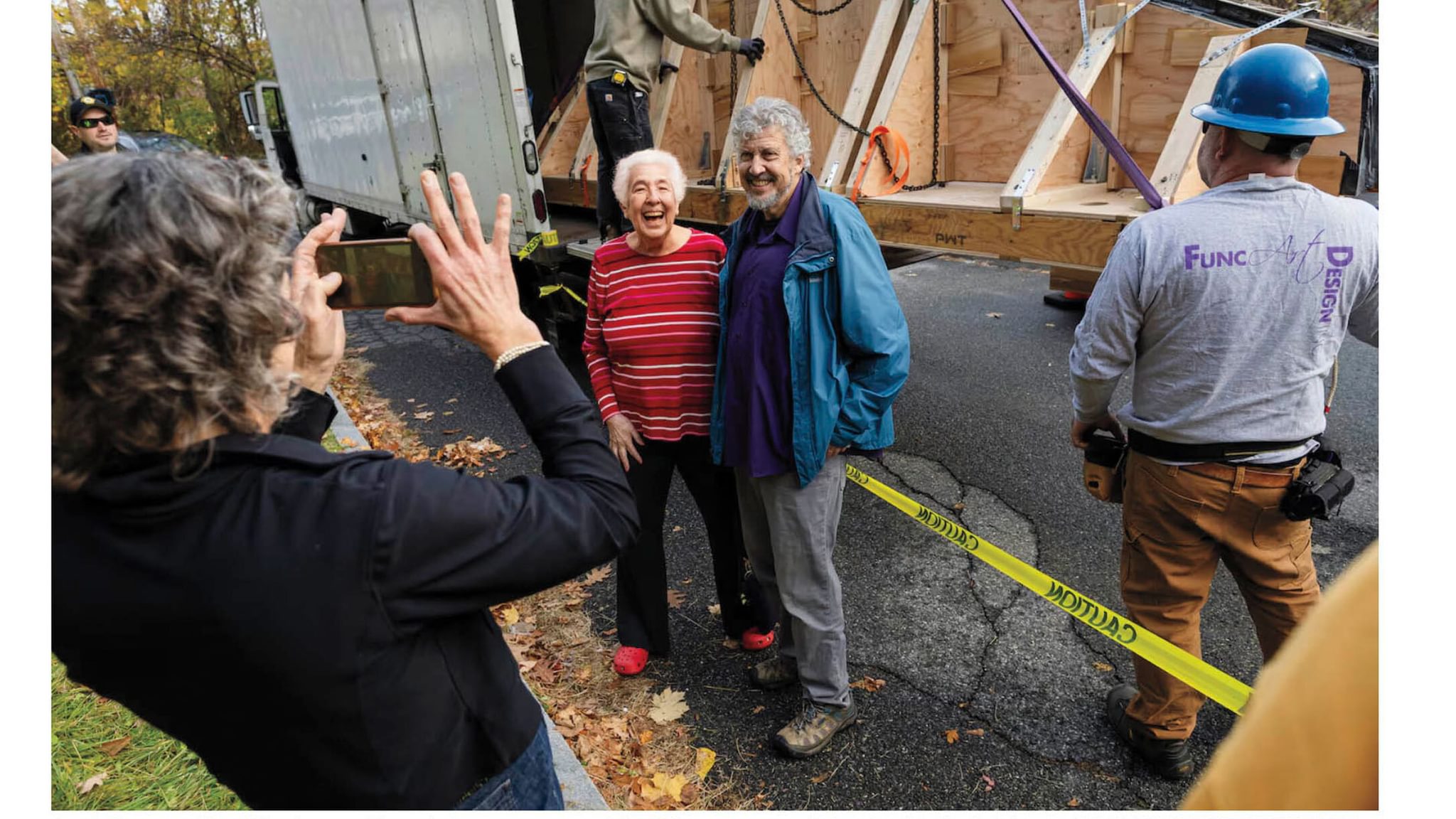 Carol Clingan '63 and David Towler, the North Adams, Mass., native who told her about the mural, pose for a photo as a crew moves it.
