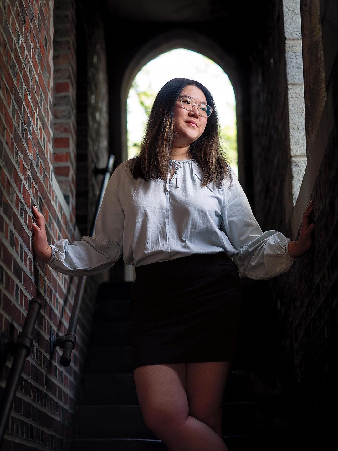 Photo of Eunice Zhang ’27 in one of the Gothic stairways outside Founders Hall